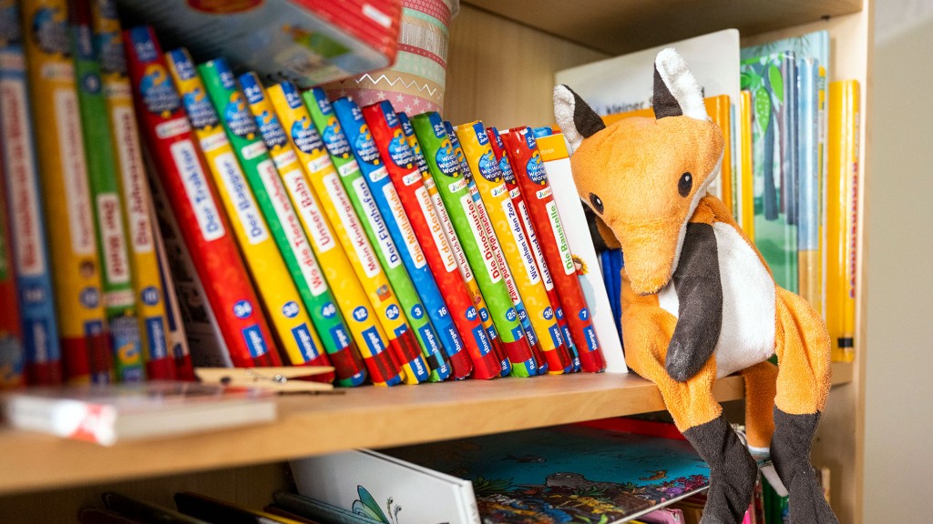 Foto: Ein Kuscheltier zwischen Kinderbüchern im Regal