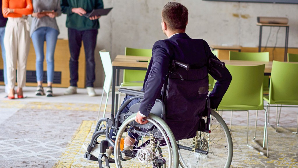 Foto: Schwerbhinderung am Arbeitsplatz: Ein Rollstuhlfahrer bei einem Geschäftstreffen