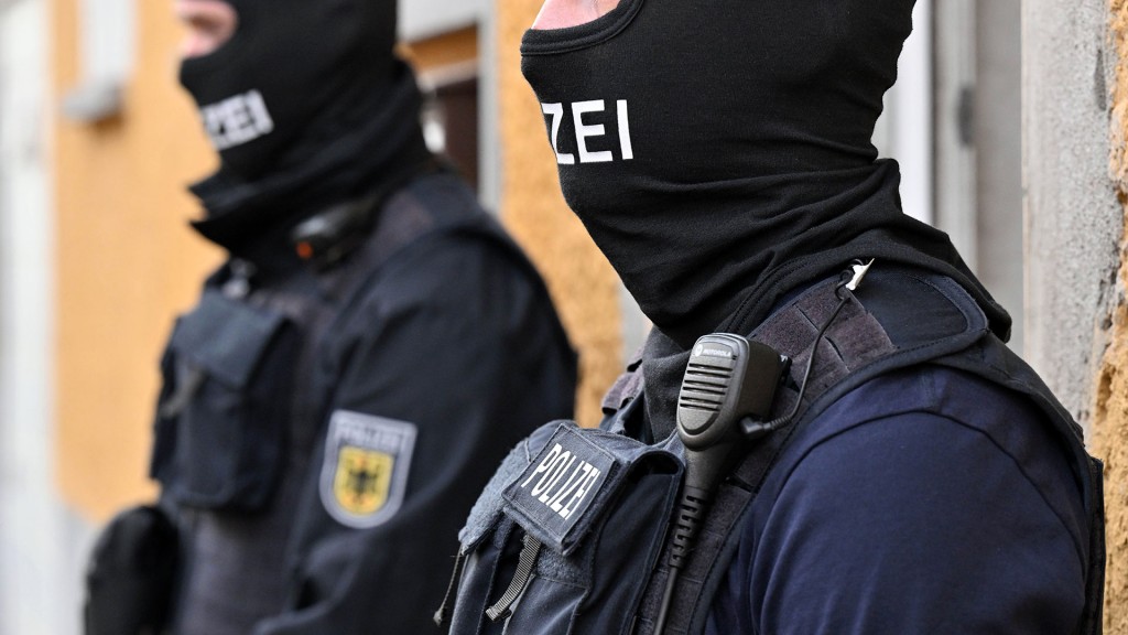 Zwei Bundespolizisten stehen vor einem Hauseingang