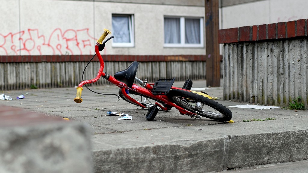 Foto: Ein Kinderfahrrad liegt in einem Aufgang zu einem Plattenbau