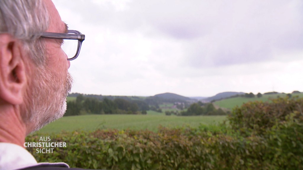 Foto: Pfarrer Wolfgang Drießen vor einer Hügellandschaft