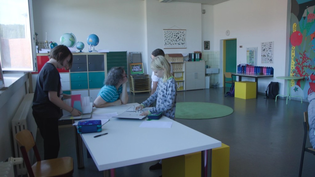 Foto: Lehrerin und SchülerInnen im Klassensaal