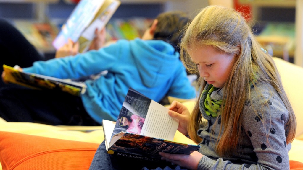 Ein Mädchen liest ein Buch auf einer Kinderbuchmesse