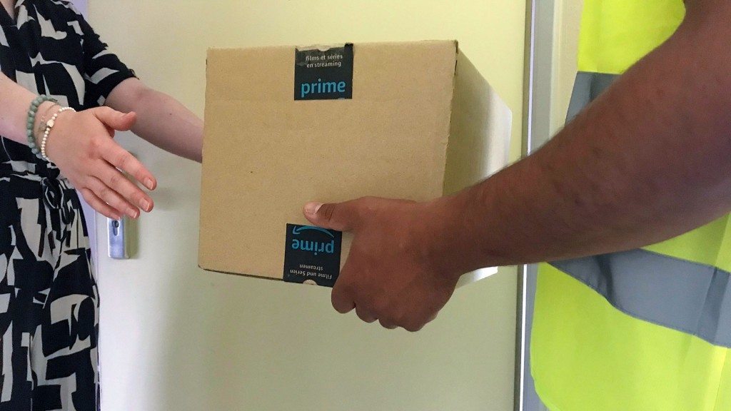 Ein Paketbote übergibt eine Amazon-Prime-Lieferung seiner Kundin an der Haustür