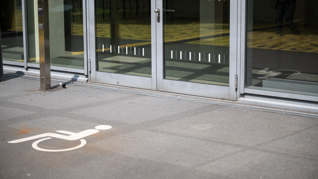 Foto: Ein Piktogramm außerhalb eines Gebäudes verweist auf einen behindertengerechten Eingang. 