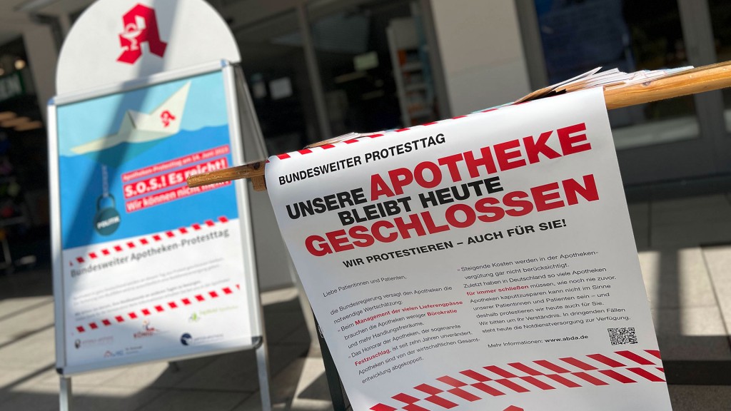 Schilder vor einer Apotheke weisen auf einen Protesttag hin