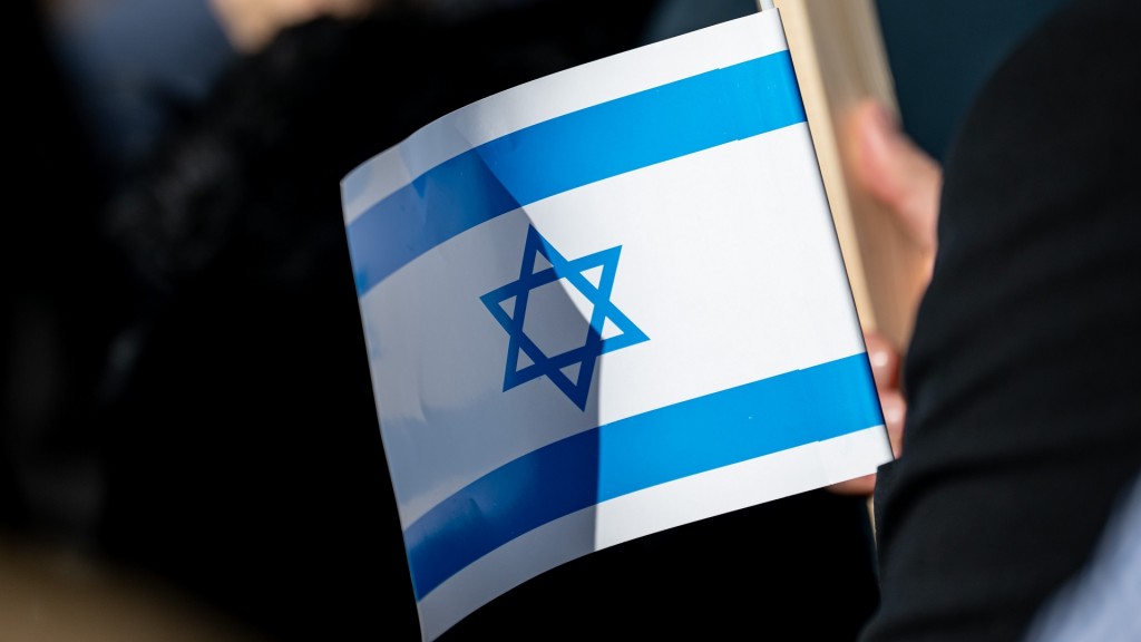 Foto: Ein Teilnehmer bei einer Solidaritätskundgebung hält eine israelische Flagge
