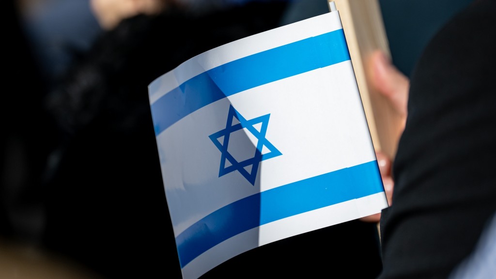 Ein Teilnehmer bei einer Solidaritätskundgebung hält eine israelische Flagge