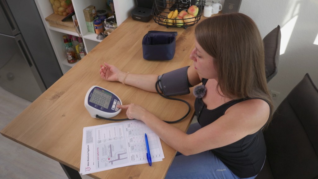 Foto: Eine Frau misst ihren Blutdruck.