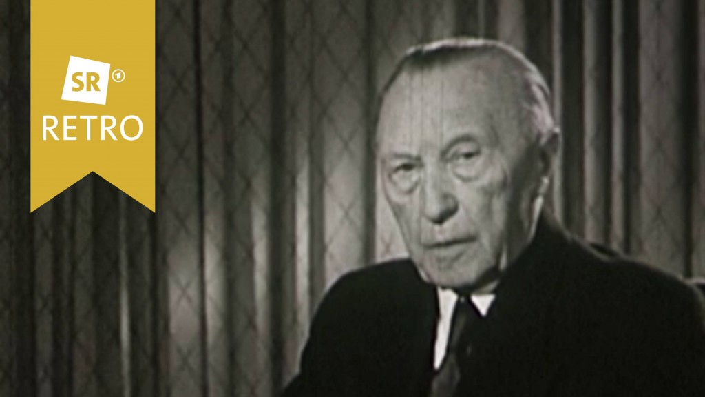Konrad Adenauer sitzt vor Mikros
