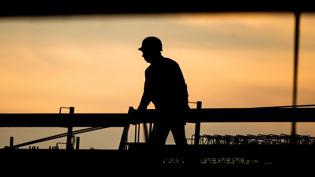 Die Silhouette eines Bauarbeiters auf einer Baustelle. 