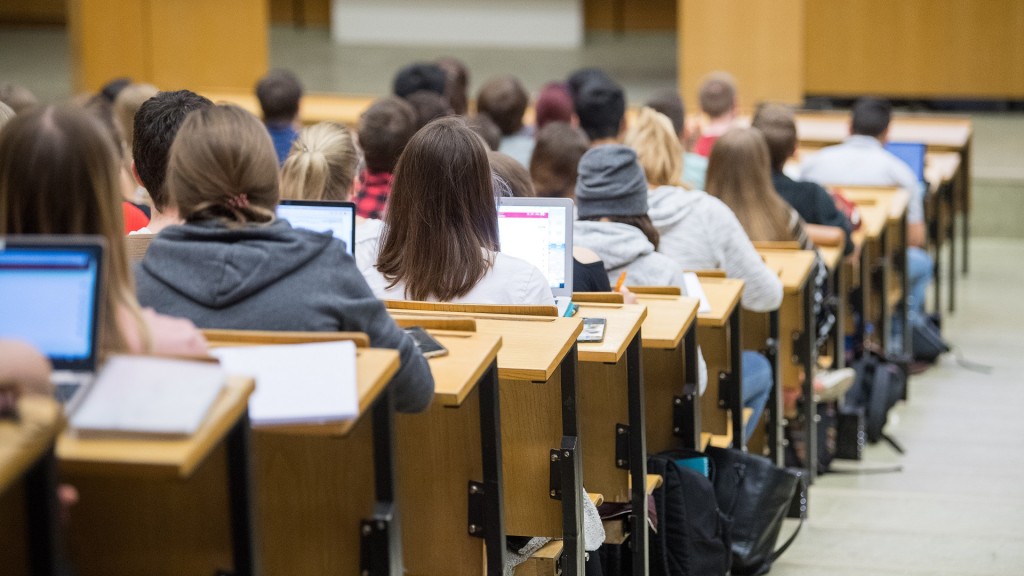 Studierende sitzen mit Laptops an der Universität in einer Vorlesung. 