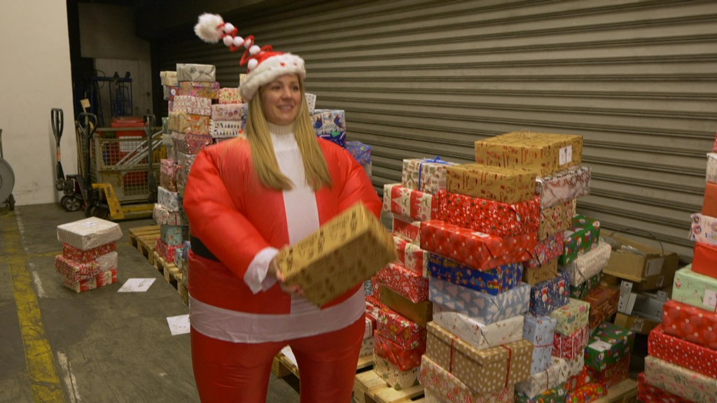 Foto: Eine Helferin bepackt den LKW mit Weihnachtspäckchen