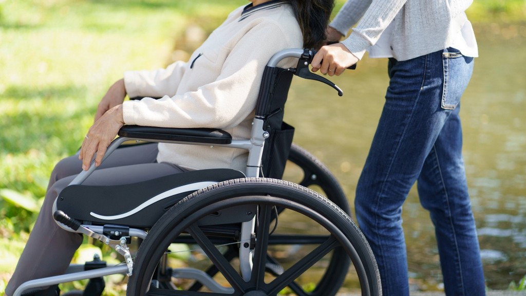 Eine behinderte Frau wird in ihrem Rollstuhl gefahren