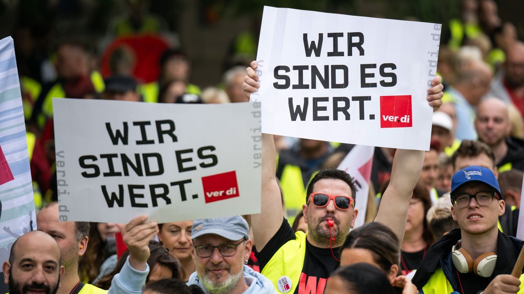 Foto: Teilnehmer der Kundgebung halten Schilder mit der Aufschrift „Wir sind es wert“ hoch