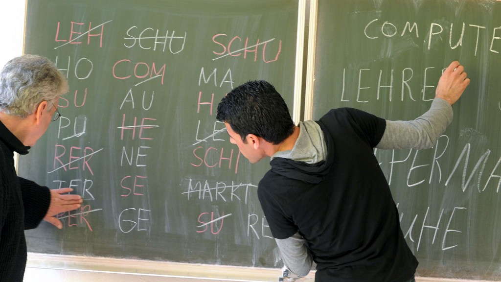 Lehrer und Schüler an der Tafel in einem Integrationskurs «Deutsch als Fremdsprache»
