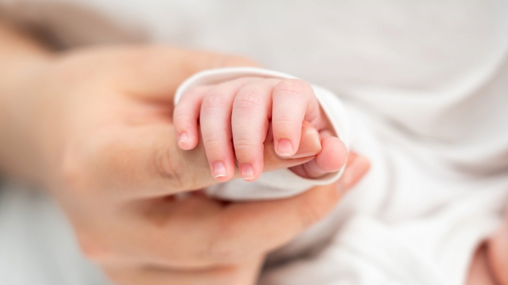 Ein Baby greift die Finger seiner Mutter