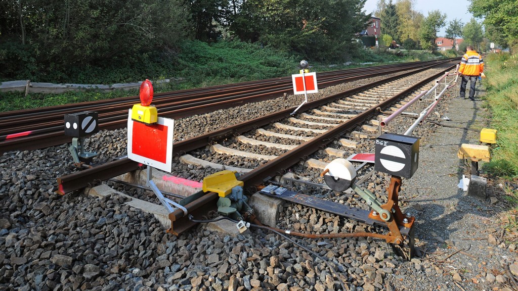 Ein Bahnmitarbeiter geht an einem gesperrten Gleis-Ende entlang