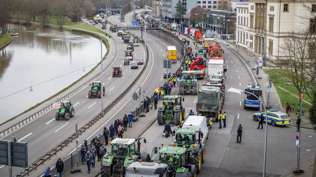 Protestierende erreichen Saarbrücken. Traktoren und weitere Fahrzeuge stehen auf der Straße vor dem Landtag.