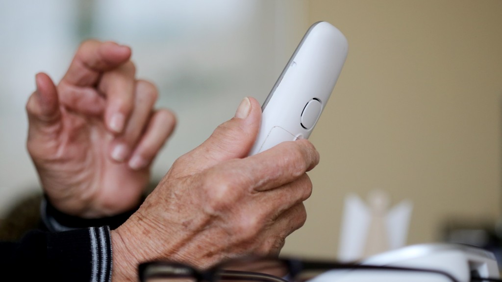 Alter Mann hält Festnetztelefon in der Hand