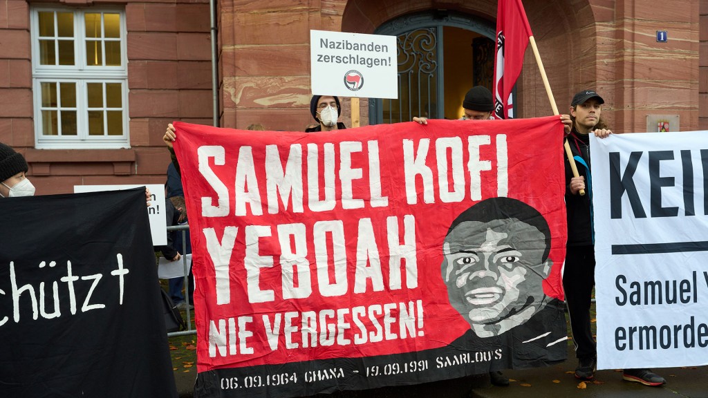 Demonstrierende erinnern mit Bannern an Samuel Yeboah vor dem Oberlandesgericht Koblenz