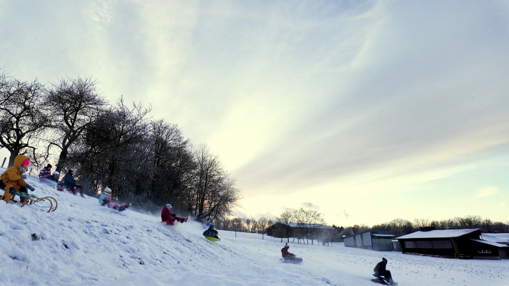 Foto: Kinder rodeln den Berg hinunter