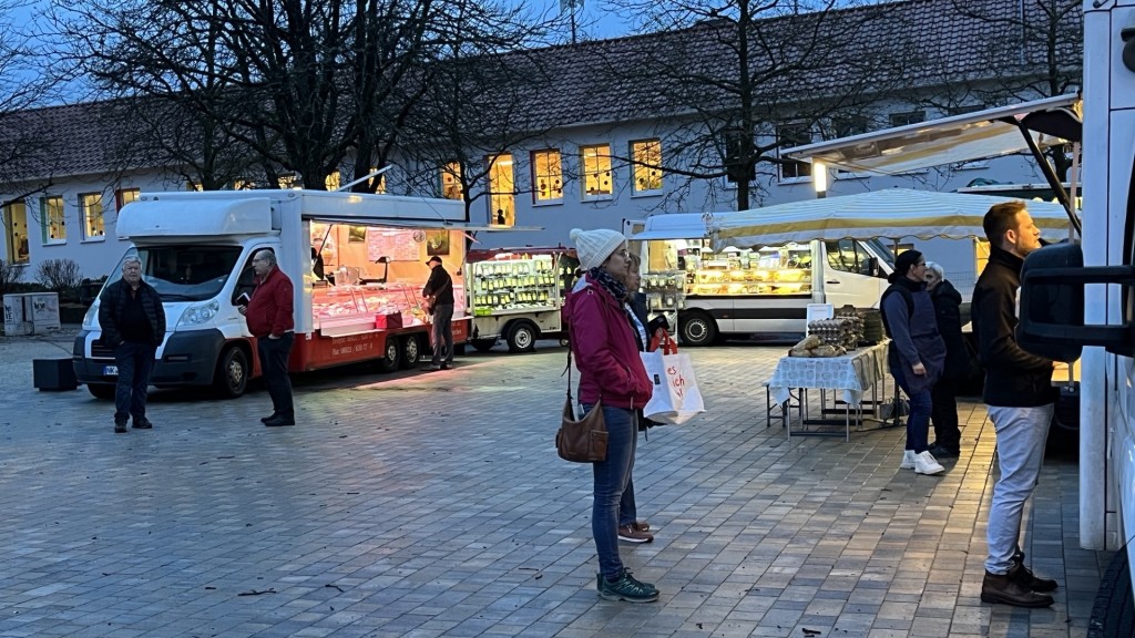 Foto: Menschen stehen auf dem Wochenmarkt in Furpach