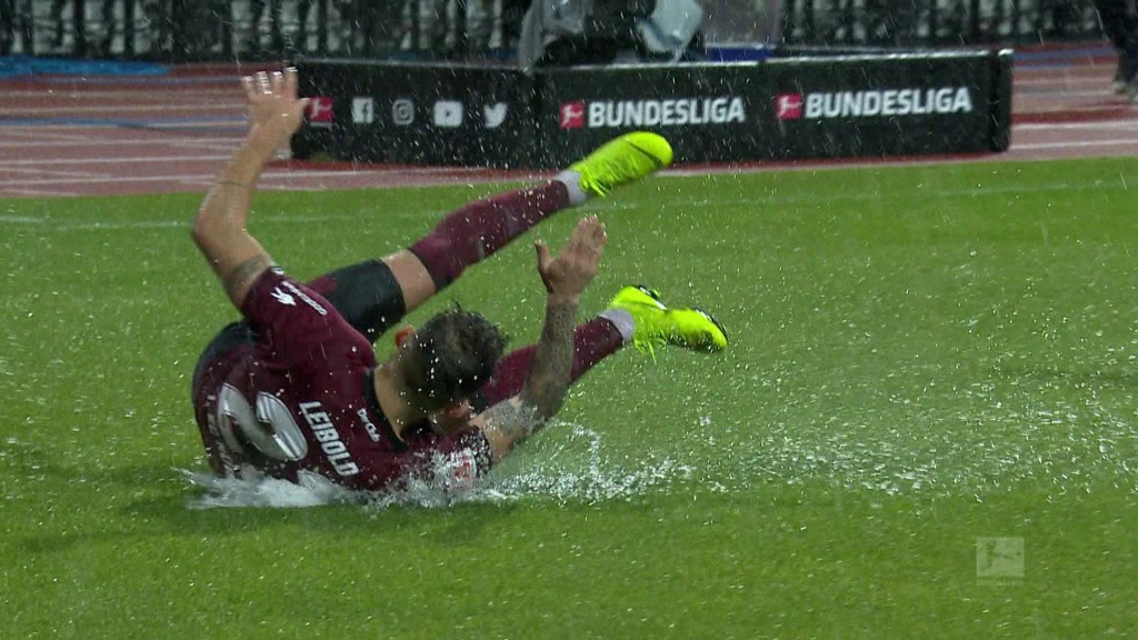 Foto: Spieler rutscht über nassen Rasen