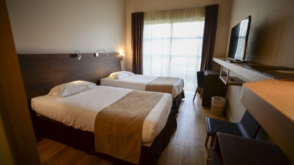 Zwei frisch bezogene Betten stehen in einem Hotelzimmer.