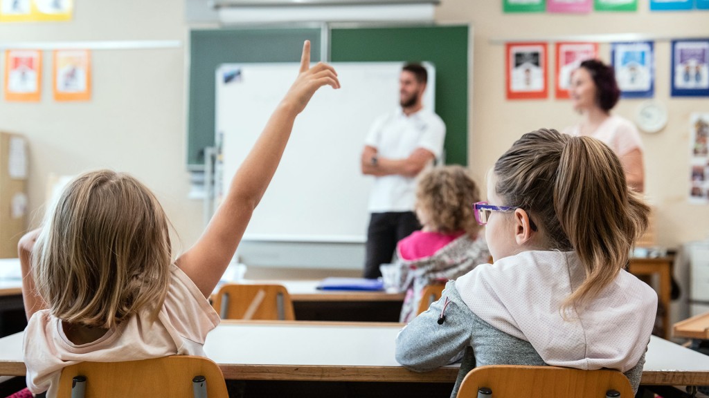 Ein Lehrer und eine Lehrering vor einer Grundschulklasse