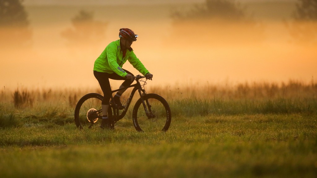 Ein Radfahrer fährt am Morgen auf einem Feldweg.