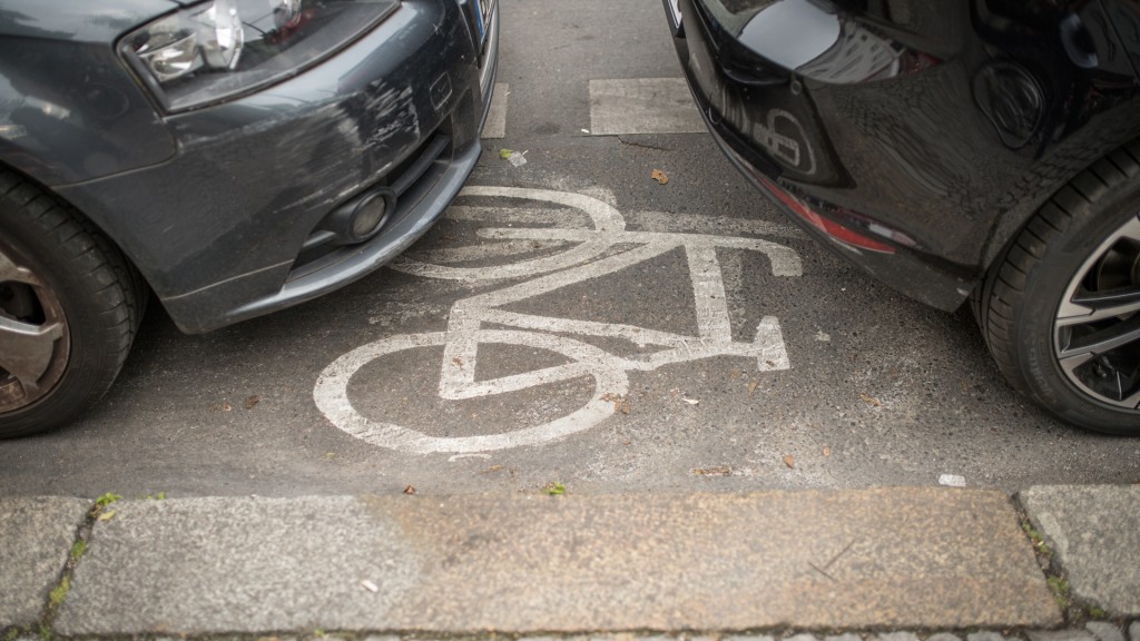 Geparkte Autos stehen auf einem Radweg