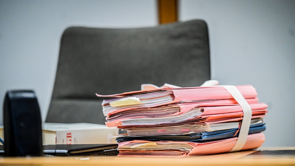 Foto: Prozessakten liegen auf dem Richtertisch in einem Gerichtssaal.