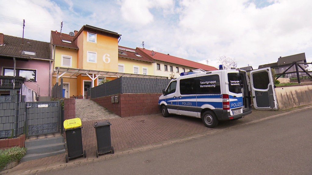 Foto: Ein Polizeiauto steht vor einem Haus