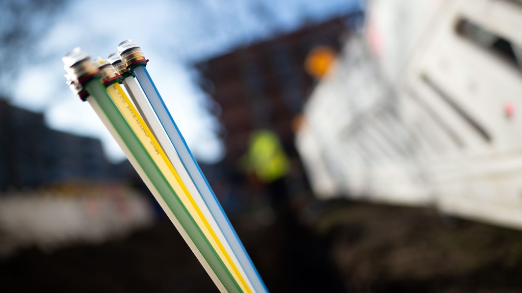 Leerrohre für Glasfaserkabel stehen an einer Baustelle aus der Grube heraus