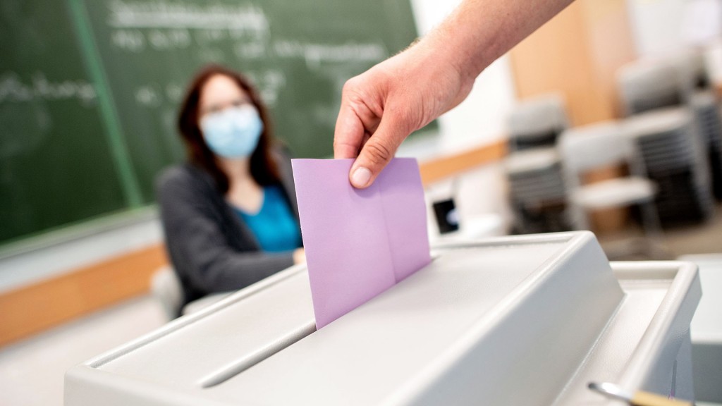 Foto: Eine Person wirft den Stimmzettel in die Wahlurne