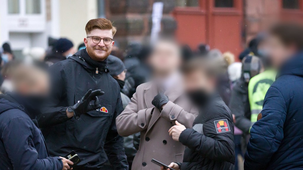 Nicolas Benyoucef zeigt das sog. „White Power“-Zeichen bei einer Anti-Corona-Demo Anfang 2022 in Saarbrücken – Weichgezeichnete Gesichter durch die Redaktion unkenntlich gemacht