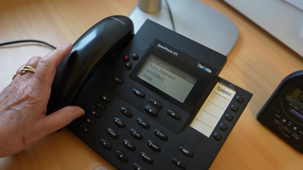 Foto: Hand greift zu Telefonapparat