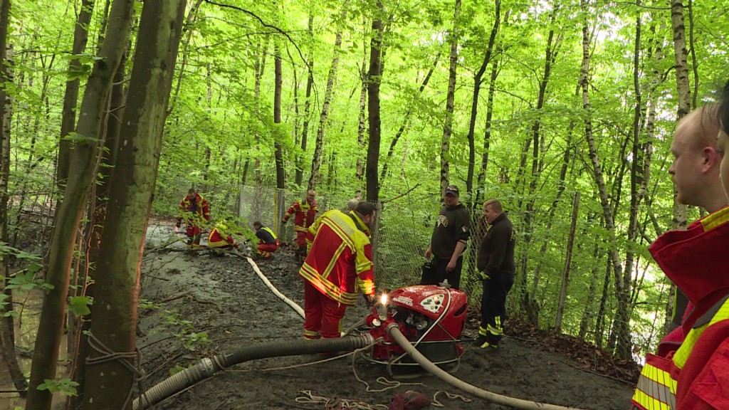 Foto: Rettungskräfte pumpen Wasser aus Auffangbecken