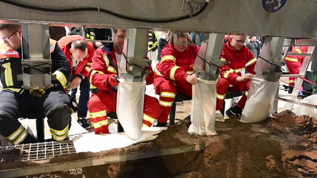 Foto: Helferinnen und Helfer befüllen Sandsäcke