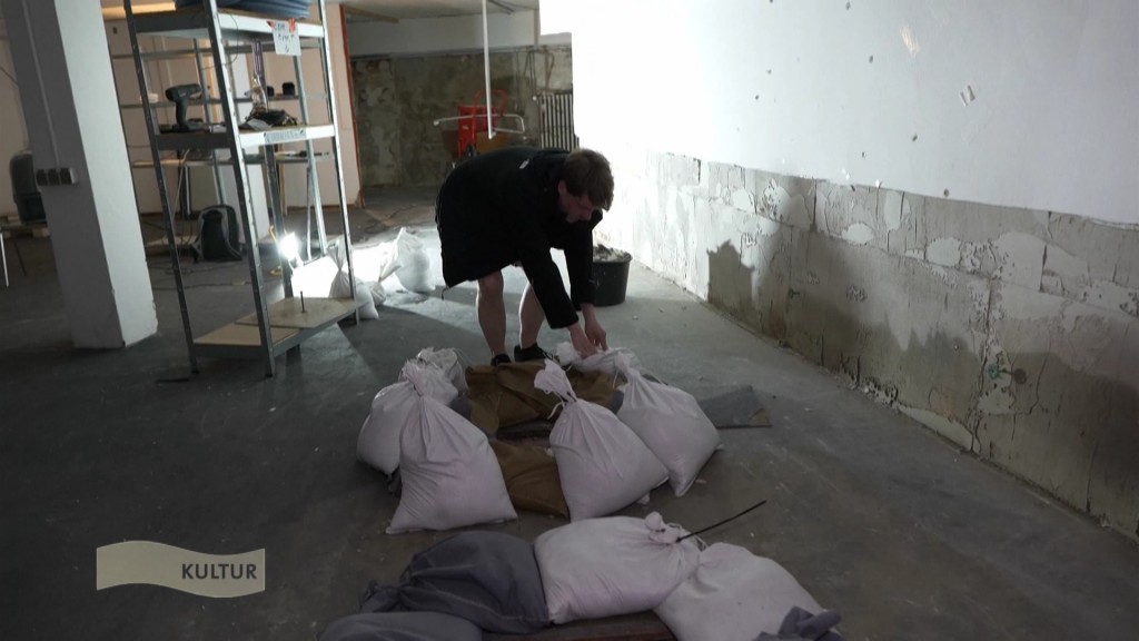 Foto: Mensch im Keller trägt Sandsäcke