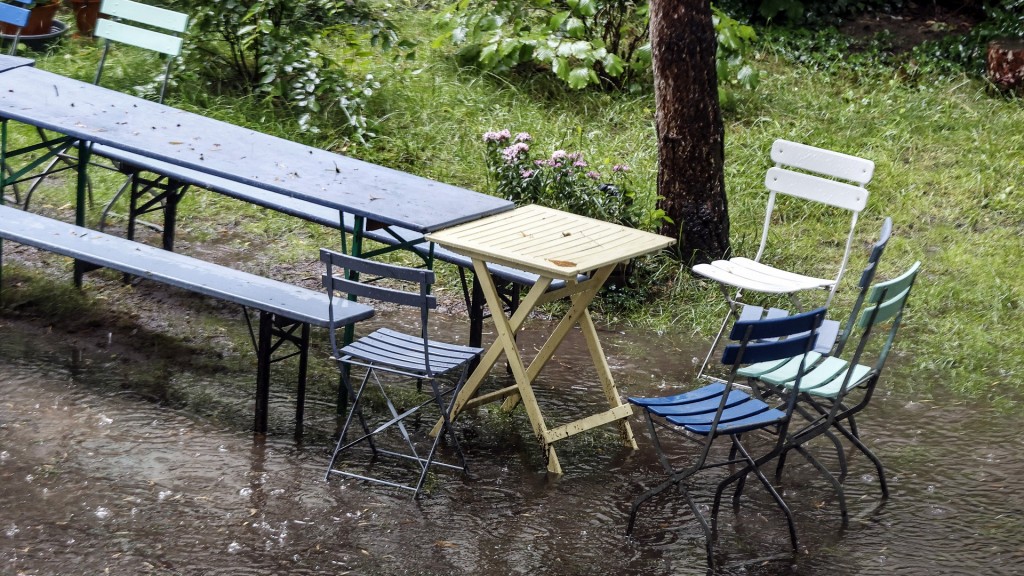 Garten mit Tisch und Stühlen im Sommer-Regenschauer