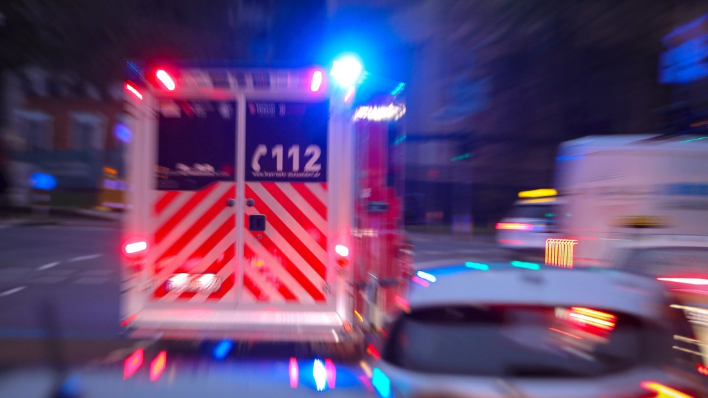 Foto: Ein Krankenwagen und Notarzt fährt mit Blaulicht durch eine Straße zu einem Einsatz
