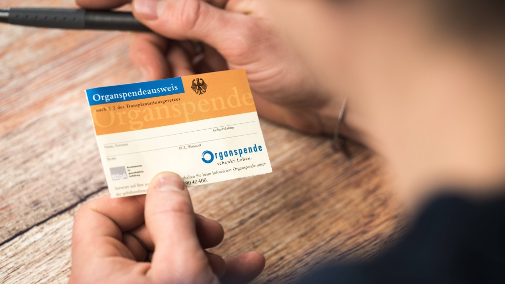 Ein Mann füllt einen Organspendeausweis aus.