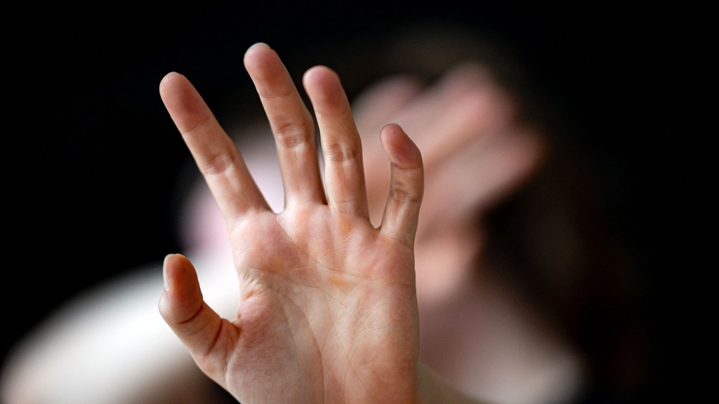 Eine Person hält ihre Hände schützend vor das Gesicht