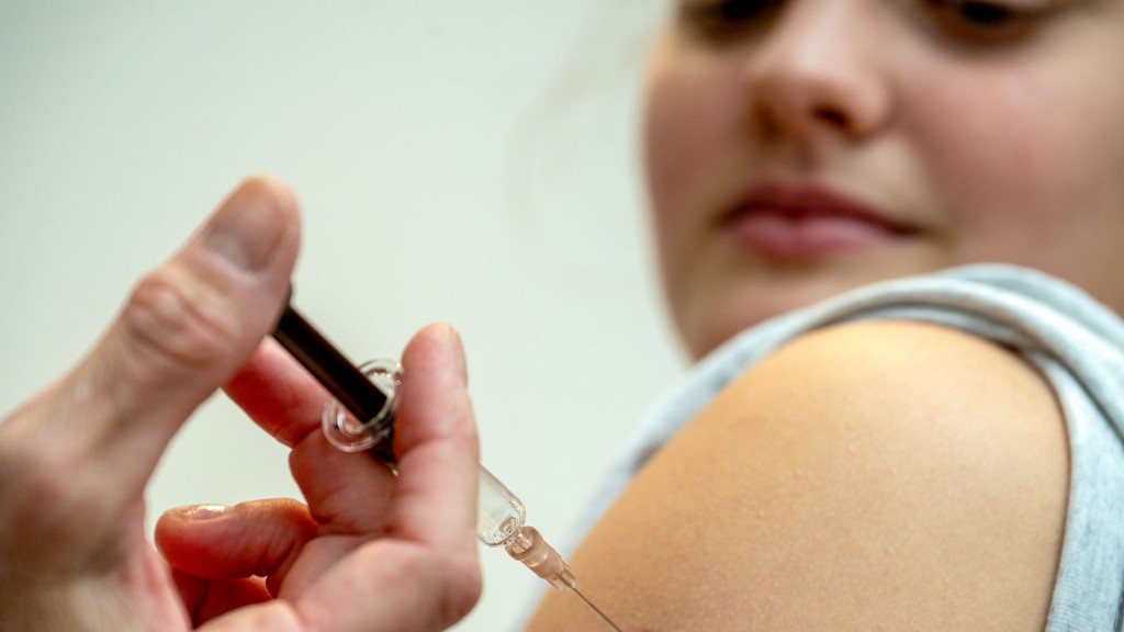 Eine Gynäkologin setzt bei der HPV-Impfung eine Injektion in den Oberarm einer Jugendlichen