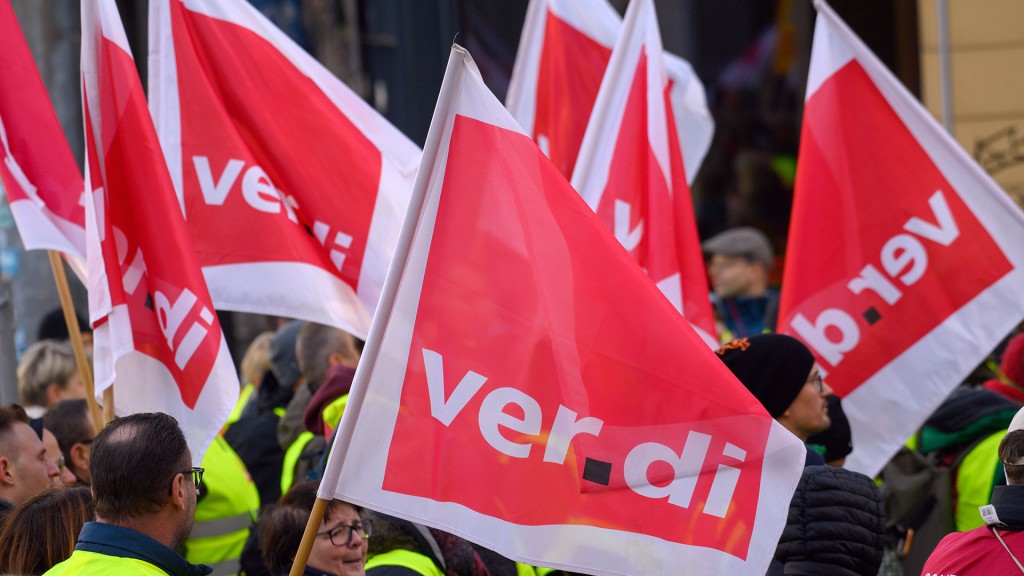 Streikende stehen mit Verdi-Fahnen