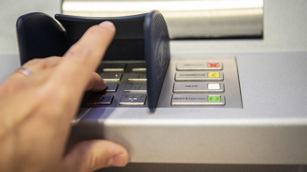 Foto: Eine Person gibt am Bankautomaten die Pin seiner Karte ein.