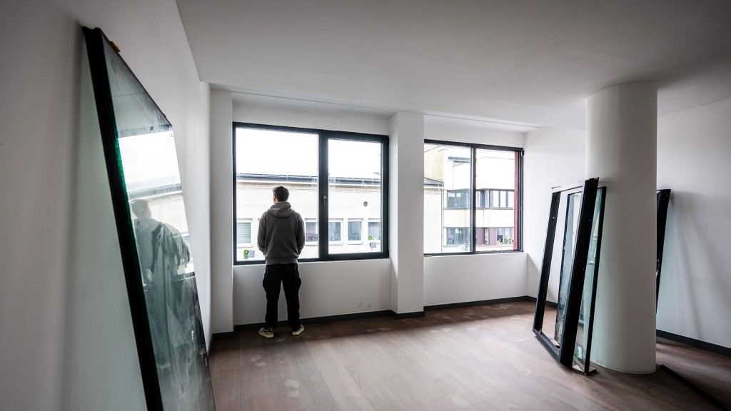 Foto: Ein Handwerker installiert neue Fenster in einem kernsanierten Wohngebäude
