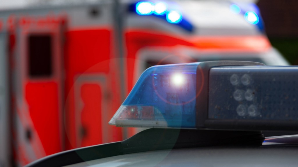 Einsatzfahrzeug, Streifenwagen der Polizei mit Blaulicht, im Hintergrund sieht man einen Rettungswagen